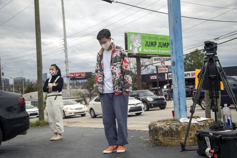 A man marks a moment of silence Friday outside of the Gold Spa, where three people died in a shooting rampage Tuesday. (Alyssa Pointer / Alyssa.Pointer@ajc.com)