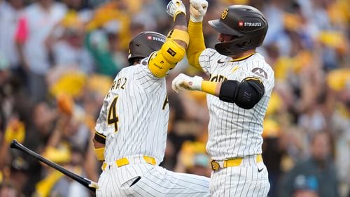 San Diego Padres' Kyle Higashioka, right, celebrate his solo home run with Luis Arraez during the second inning in Game 2 of an NL Wild Card Series baseball game against the Atlanta Braves, Wednesday, Oct. 2, 2024, in San Diego. (AP Photo/Gregory Bull)