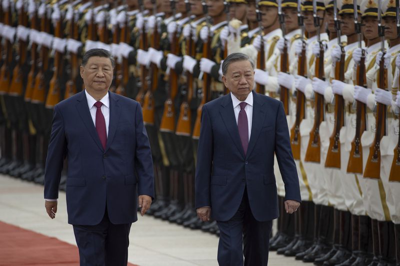 Chinese President Xi Jinping, left, walks next to Vietnam's President To Lam as they pass by the honor guard during a welcome ceremony at the Great Hall of the People in Beijing Monday, Aug. 19, 2024. (Andres Martinez Casares/Pool Photo via AP)