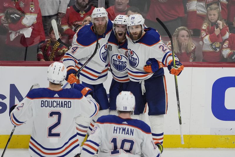 Edmonton Oilers players congratulate center Connor McDavid (97) after McDavid scored a goal during the third period of Game 5 of the NHL hockey Stanley Cup Finals against the Florida Panthers, Tuesday, June 18, 2024, in Sunrise, Fla. The Oilers defeated the Panthers 5-3. (AP Photo/Rebecca Blackwell)