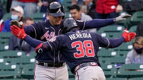 Braves Guillermo Heredia (38) and Austin Riley celebrate after Heredia hit a two-run home run during the first inning Sunday, April 18, 2021,  against the Chicago Cubs at Wrigley Field in Chicago. (Nam Y. Huh/AP)