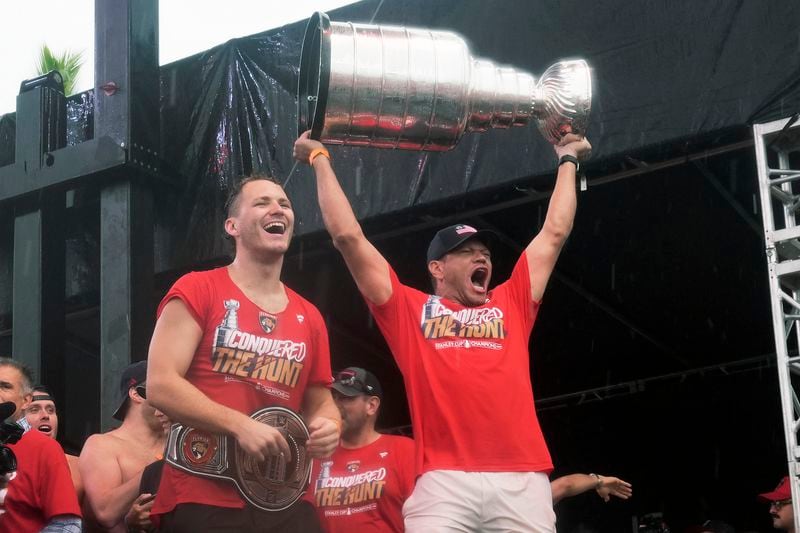 Florida Panthers' Matthew Tkachuk, left, and Kyle Okposo, right, celebrate with the Stanley Cup during an NHL hockey parade and rally, Sunday, June 30, 2024, in Fort Lauderdale, Fla. The Panthers defeated the Edmonton Oilers to win the championship series. (AP Photo/Marta Lavandier)