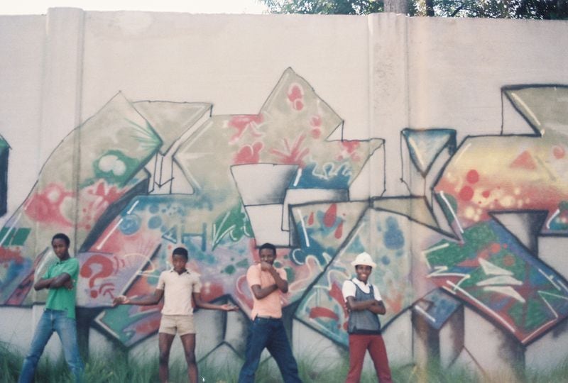 Members of the United Kings Fernando "ESKEME2" Alexander (from left),  Hackwin "ESKAN" Devoe, Dwayne "Just One" Devoe and Dexter "DEQUE" Gilmore in front of their piece next to the Arts Center MARTA station in 1985.
Courtesy of Rodney "RAD1" Wills