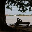 FILE - A man sits on the banks of the Suriname River in Paramaribo, Suriname, Aug. 10, 2010. (AP Photo/Andres Leighton, File)