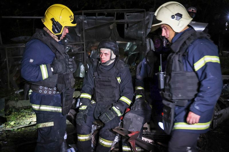 Firefighters take a break after working at the scene after a Russian strike on a residential building in Kharkiv, Ukraine early Sunday Sept. 22, 2024. (Kharkiv Regional Military Administration via AP)