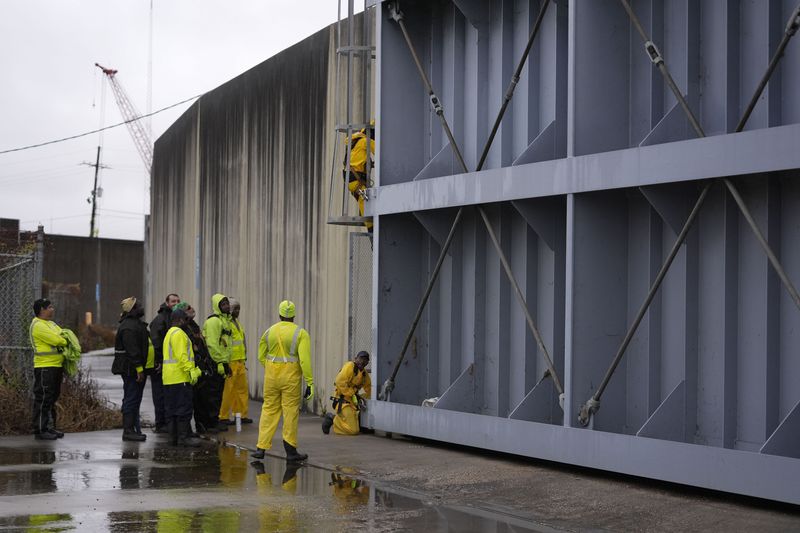 Workers from the Southeast Louisiana Flood Protection Authority-West tighten turnbuckles as they close floodgates along the Harvey Canal, just outside the New Orleans city limits, in anticipation of Tropical Storm Francine, in Harvey, La., Tuesday, Sept. 10, 2024. (AP Photo/Gerald Herbert)