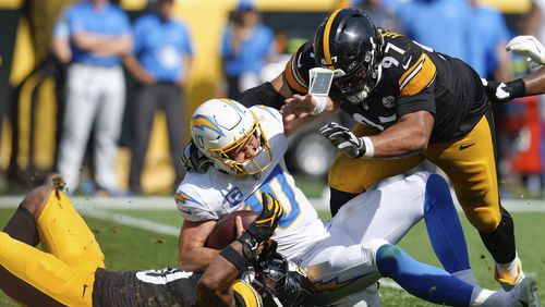 Los Angeles Chargers quarterback Justin Herbert (10) is sacked by Pittsburgh Steelers linebacker Elandon Roberts, bottom left, during the second half of an NFL football game, Sunday, Sept. 22, 2024, in Pittsburgh. (AP Photo/Gene J. Puskar)