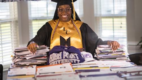 Liberty County High School graduate Madison Crowell, who has received college scholarship offers totaling more than $14 million, poses with some of the offers laid out on her family's dining room table on Wednesday, May 29, 2024 in Hinesville, Georgia. (AJC Photo/Stephen B. Morton)
