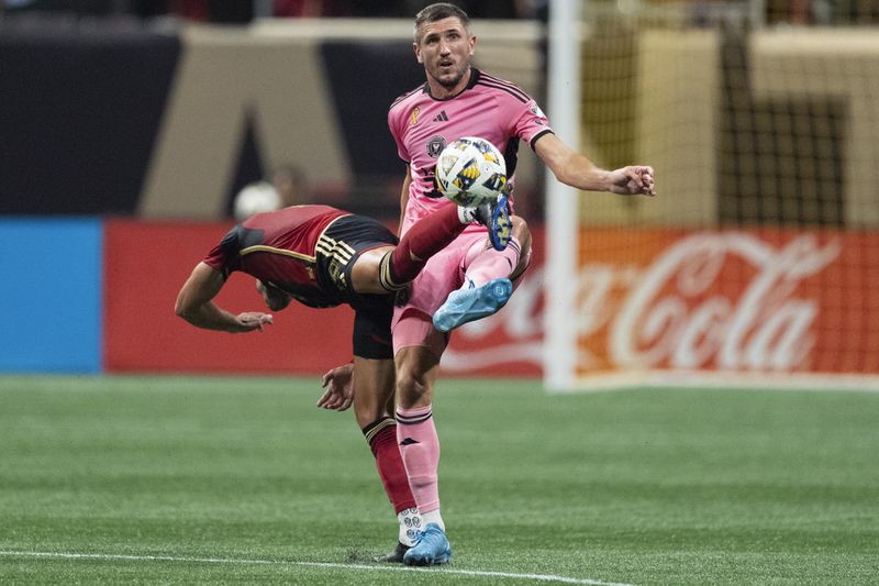 Inter Miami defender Serhiy Kryvtsov (27) and Atlanta United forward Daniel Ríos (19) battle for the ball during thre first half of a MLS soccer match Wednesday, Sept. 18, 2024. (AP Photo/John Bazemore)