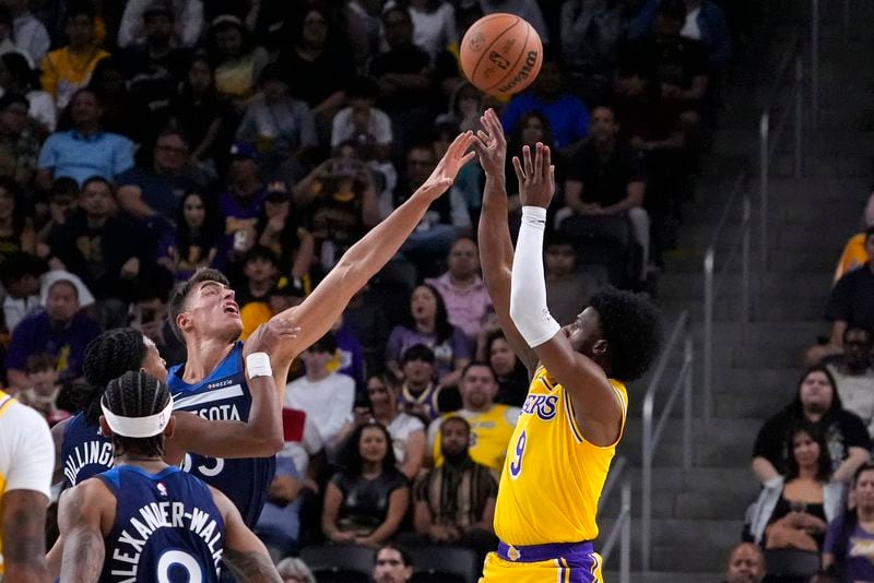 Los Angeles Lakers guard Bronny James, right, shoots as Minnesota Timberwolves center Luka Garza defends during the first half of a preseason NBA basketball game, Friday, Oct. 4, 2024, in Los Angeles. (AP Photo/Mark J. Terrill)