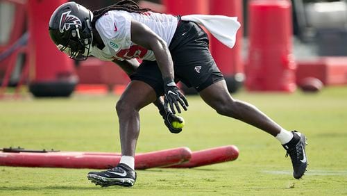 Atlanta Falcons outside linebacker De'Vondre Campbell (59) picks up a softball as he runs a drill during the team's NFL training camp football practice Friday, July 28, 2017, in Flowery Branch, Ga. (AP Photo/John Bazemore)