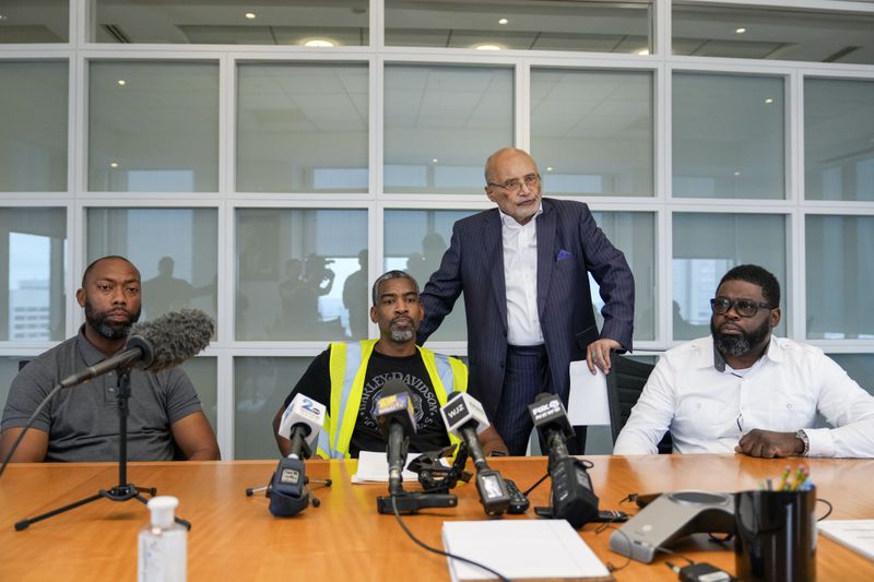 Attorney William Murphy, third from left, speaks during a press conference announcing a class action claim against the owners of the Dali seeking damages for economic losses suffered by Longshoreman Union members, with union members Ryan Hale, Anthony Wynn and Alonzo Key, Thursday, Sept. 26, 2024, in Baltimore. (AP Photo/Stephanie Scarbrough)