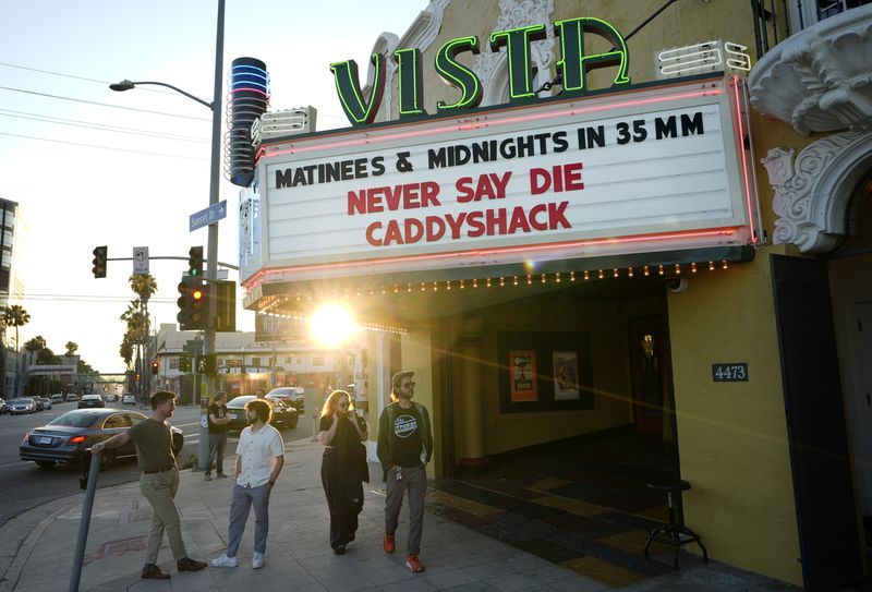 Pedestrians gather under the marquee of the Vista Theatre, Friday, Aug. 2, 2024, in Los Angeles. (AP Photo/Chris Pizzello)