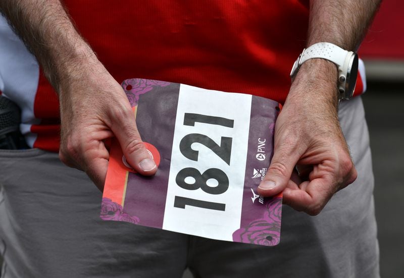 Rich Kenah, executive director of Atlanta Track Club, shows a race bib for the AJC Peachtree Road Race during a press briefing Tuesday.  (Hyosub Shin / Hyosub.Shin@ajc.com)