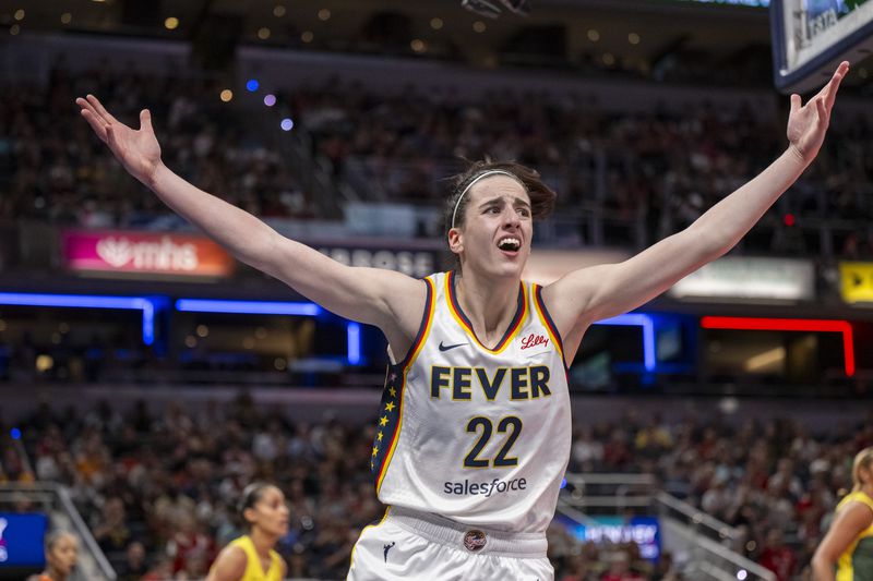 FILE - Indiana Fever guard Caitlin Clark reacts after scoring against the Seattle Storm during the first half of a WNBA basketball game, May 30, 2024, in Indianapolis. Not even a WNBA basketball game is an escape from the arguments and polarization that are so common in American life these days. (AP Photo/Doug McSchooler, File)