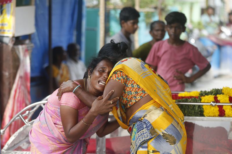 A relative of a man, who died after drinking illegally brewed liquor, cries next to the casket containing his body in Kallakurichi district of the southern Indian state of Tamil Nadu, India, Thursday, June 20, 2024. The state's chief minister M K Stalin said the 34 died after consuming liquor that was tainted with methanol, according to the Press Trust of India news agency. (AP Photo/R. Parthibhan)