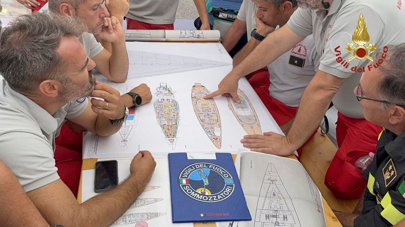 In this picture released by the Italian Firefighters Tuesday, Aug. 20, 2024, Scuba divers study a map of the sailing yacht Bayesian at the Porticello harbor. Rescue teams and divers returned to the site of a storm-sunken superyacht Tuesday to search for six people, including British tech magnate Mike Lynch, who are believed to be still trapped in the hull 50 meters (164-feet) underwater. (Italian Firefighters via AP, HO)