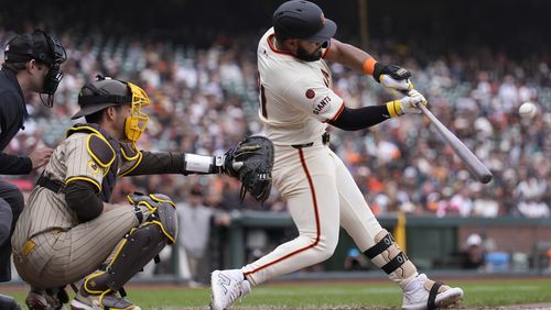 San Francisco Giants' Heliot Ramos, right, hits a home run in front of San Diego Padres catcher Kyle Higashioka during the ninth inning of a baseball game in San Francisco, Sunday, Sept. 15, 2024. (AP Photo/Jeff Chiu)