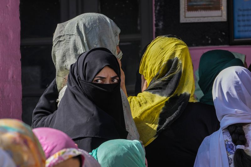 Kashmiris queue up at a polling booth to cast their vote during the final phase of an election to choose a local government in Indian-controlled Kashmir, north of Srinagar, Tuesday, Oct.1, 2024. (AP Photo/Mukhtar Khan)