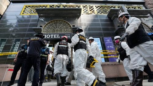 A joint investigation team arrives to examine the site of a hotel burnt by Thursday's fire in Bucheon, South Korea, Friday, Aug. 23, 2024. (AP Photo/Ahn Young-joon)