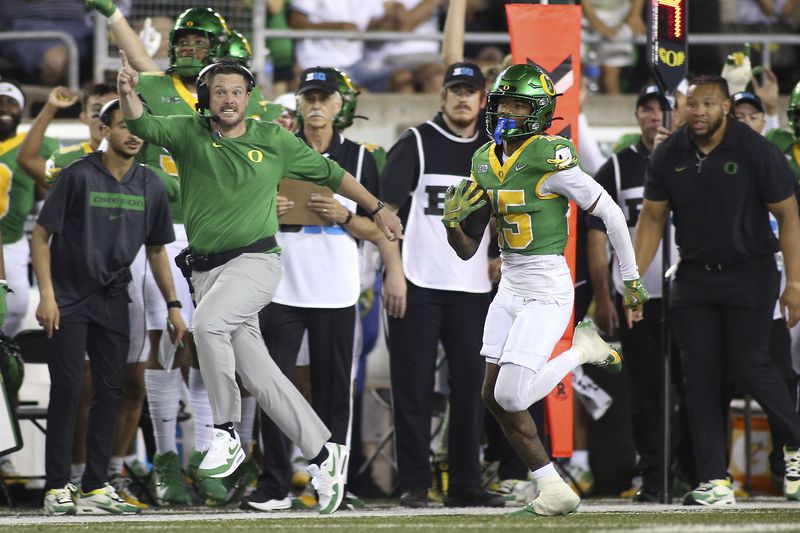 Oregon head coach Dan Lanning cheers on wide receiver Tez Johnson (15) during Johnson's touchdown punt return in the second half of an NCAA college football game, Saturday, Sept. 7, 2024, at Autzen Stadium in Eugene, Ore. (AP Photo/Lydia Ely)