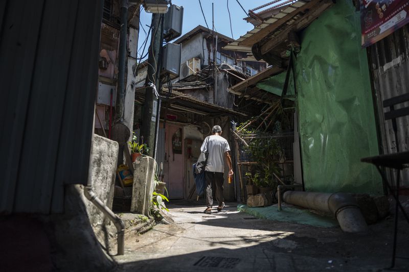 A villager walks through the Cha Kwo Ling village in east Kowloon, Hong Kong, Sunday, Aug. 25, 2024. (AP Photo/Chan Long Hei)