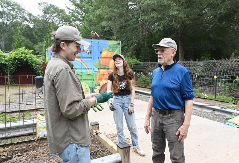 Colin Henderson (left) and Laura Smith (center), granddaughter of Joe Eifrid (right), volunteer their time to help make the Rockdale Art Farm a place where the community can enjoy nature and be inspired. (Hyosub Shin / AJC)