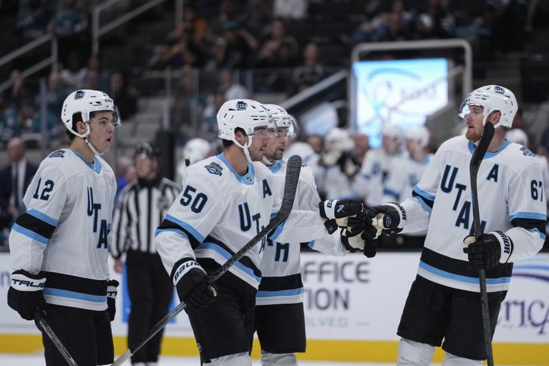 Utah Hockey Club defenseman Sean Durzi (50) celebrates with Lawson Crouse, right, after scoring a goal during the second period of a pre-season NHL hockey game against the San Jose Sharks, Tuesday, Oct. 1, 2024, in San Jose, Calif. (AP Photo/Godofredo A. Vásquez)