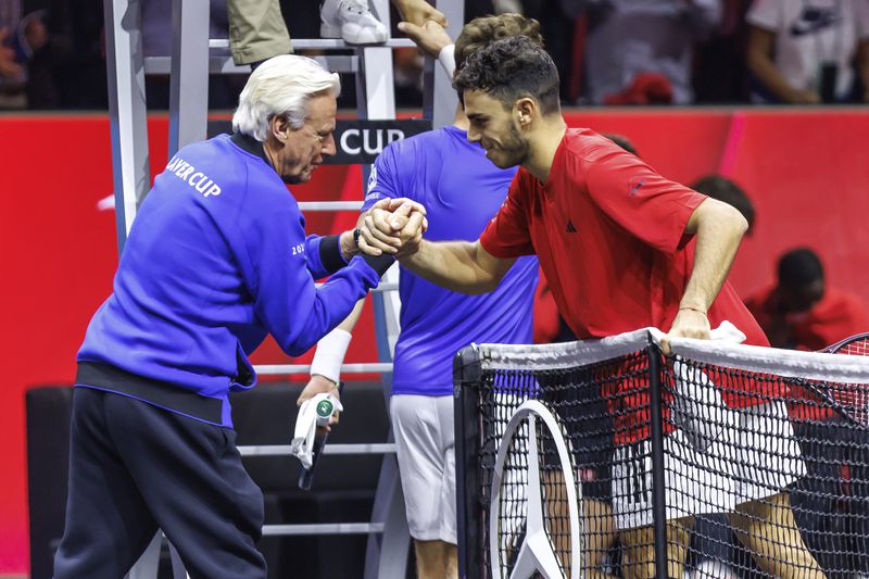 Argentina's Francisco Cerundolo says goodbye to captain Björn Borg after winning his match against Norway's Casper Ruud during their men's singles Laver Cup tennis match at the Uber Arena in Berlin, Germany, Friday Sept. 20, 2024. (Andreas Gora/dpa via AP)