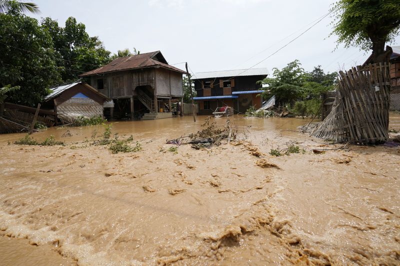 Debris from half-submerged residences float on a flooded road in Naypyitaw, Myanmar, Saturday, Sept. 14, 2024. (AP Photo/Aung Shine Oo)