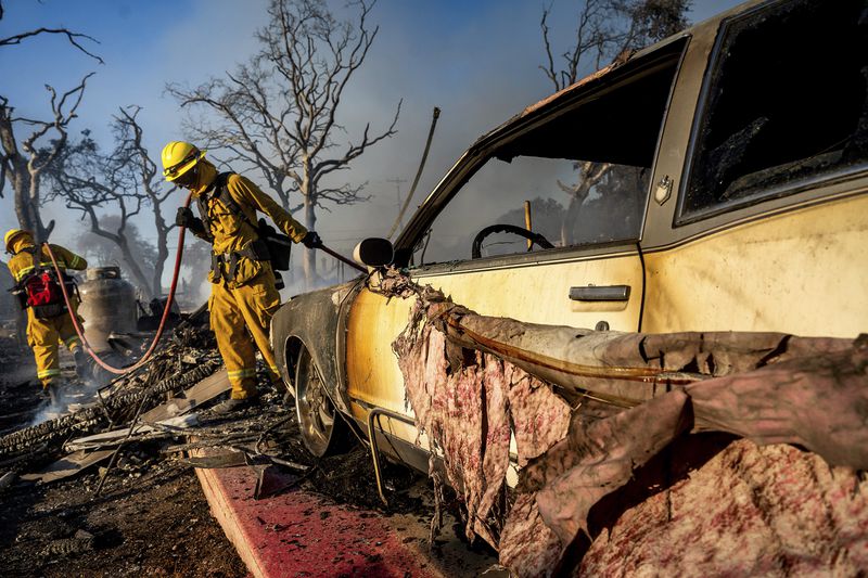 Firefighters extinguish hot spots as the Boyles fire burns in Clearlake, Calif., on Sunday, Sept. 8, 2024. (AP Photo/Noah Berger)