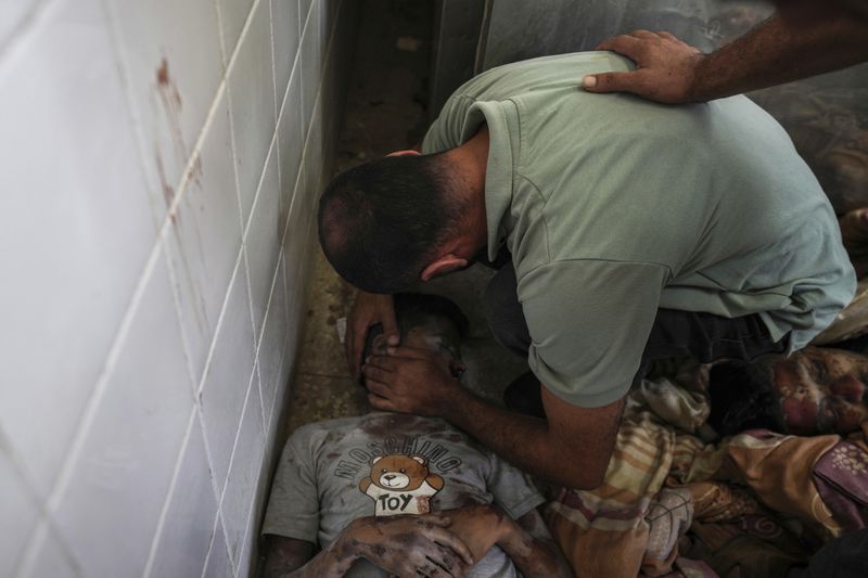 A Palestinian man mourns a relative killed in the Israeli bombardment of the Gaza Strip, at a hospital in Deir al-Balah, Tuesday, Aug. 27, 2024. (AP Photo/Abdel Kareem Hana)