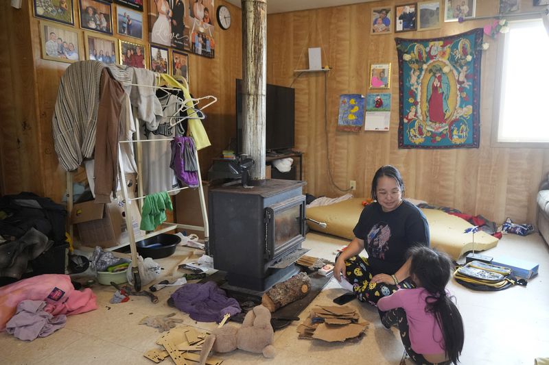 Jennifer sits with her daughter Girlie, 4, at their home on Saturday, Aug. 17, 2024, in Mertarvik, Alaska. (AP Photo/Rick Bowmer)