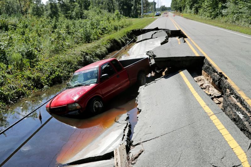 A pickup truck sits in a washed out section of road on Old Ocean Highway in Supply, N.C., Tuesday, Sept. 17, 2024. (AP Photo/Chris Seward)