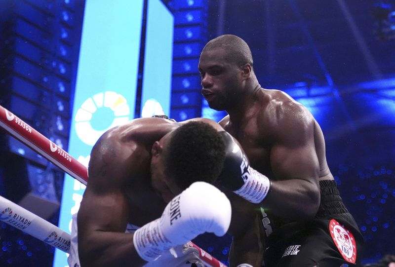 Daniel Dubois, right, knocks down Anthony Joshua in the IBF World Heavyweight bout at Wembley Stadium, in London, Saturday Sept. 21, 2024. (Bradley Collyer/PA via AP)