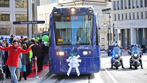 December 30, 2014 Atlanta - Crowds gather as an Atlanta Streetcar arrives during a grand opening ceremony at Woodruff Park on Tuesday, December 30, 2014. After escalating costs and a series of delays, the Atlanta street car finally rolled through a stretch of downtown Atlanta. President Obama's transportation legacy hinges on his ability to move the nation toward rail, and the streetcar is one of the first completed projects aimed at making the nation more rail oriented. And the city sees the streetcar as the first of many streetcars that will create an auxiliary transit system over time, attracting investment and creating jobs. HYOSUB SHIN / HSHIN@AJC.COM