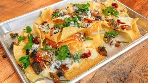 Macho Nachos, crunchy corn tortillas, queso sauce, charred veggies, cotija and herbs, plus  add your favorite slow-cooked meat. CONTRIBUTED BY CHRIS HUNT PHOTOGRAPHY)