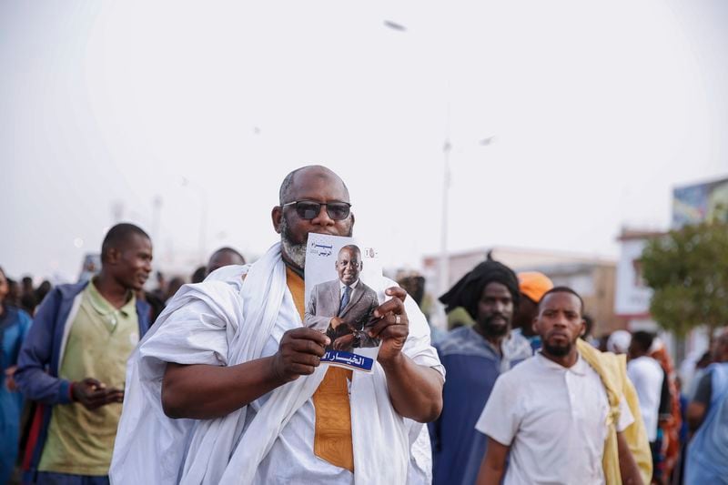 A supporter of presidential candidate Biram Ould Dah Ould Abeid, holds his poster during his campaign rally ahead of the presidential election end of the month, in Nouakchott, Mauritania, Monday, June 24, 2024. (AP Photo/Mamsy Elkeihel)