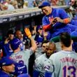 New York Mets' Pete Alonso, lower left, high fives a teammate after hitting an RBI sacrifice fly during the eighth inning of Game 1 of a baseball NL Division Series against the Philadelphia Phillies, Saturday, Oct. 5, 2024, in Philadelphia. (AP Photo/Chris Szagola)