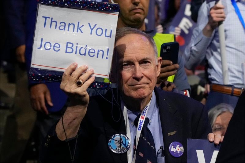 A delegate holds a sign as President Joe Biden speaks during the first day of Democratic National Convention, Monday, Aug. 19, 2024, in Chicago. (AP Photo/Jacquelyn Martin)