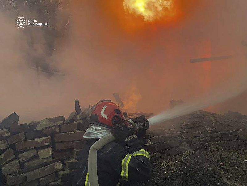 In this photo provided by the State Emergency Service of Ukraine, a rescue worker tries to extinguish a fire of a burning building destroyed by a Russian strike in Lviv, Ukraine, Wednesday, Sept. 4, 2024. (State Emergency Service of Ukraine via AP)