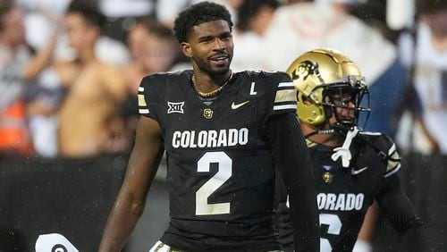 Colorado quarterback Shedeur Sanders, front, and wide receiver Drelon Miller celebrate after an overtime victory over Baylor in an NCAA college football game Saturday, Sept. 21, 2024, in Boulder, Colo. (AP Photo/David Zalubowski)