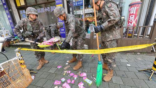 South Korean army soldiers collect the trash from a balloon presumably sent by North Korea, in Incheon, South Korea, Wednesday, July 24, 2024. (Lim Sun-suk//Yonhap via AP)