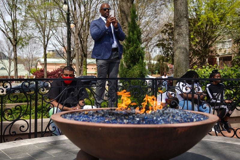 People listen to a speaker as the eternal flame burns at a wreath laying ceremony at The King Center on the 54th anniversary of the assassination of Dr. Martin Luther King Jr., on Monday, April 4, 2022, in Atlanta. (Elijah Nouvelage/Special to the Atlanta Journal-Constitution)