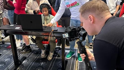 Andre DeRamus, standing in white shirt, is founder and executive director of The Creative Academy. The nonprofit offers free training to Atlanta's inner-city teens in creative arts like film, video recording and photography. Courtesy of The Creative Academy