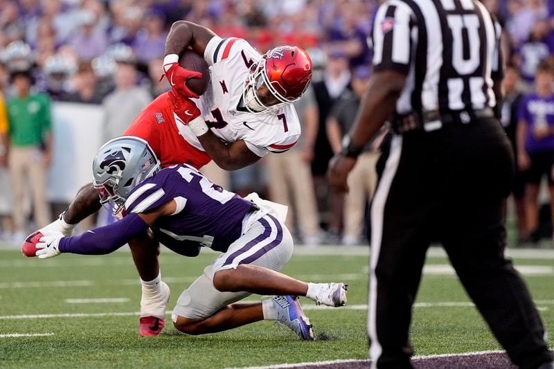 Arizona running back Quali Conley (7) dives over Kansas State safety Marques Sigle (21) to score a touchdown during the first half of an NCAA college football game Friday, Sept. 13, 2024, in Manhattan, Kan. (AP Photo/Charlie Riedel)