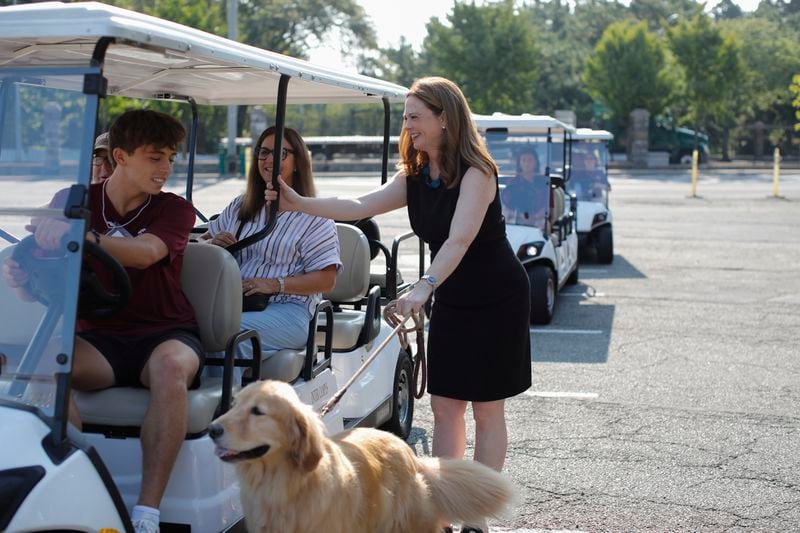 Tania Tetlow, president of Fordham University, holds her dog Archie as she meets new students during Move In Day at the Bronx campus, Sunday, Aug. 25, 2024, in New York. (AP Photo/Kena Betancur)