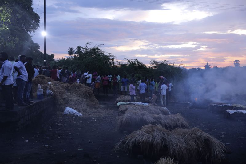 Funeral pyres burn at a mass cremation for people, who died after drinking illegally brewed liquor, in Kallakurichi district of the southern Indian state of Tamil Nadu, India, Thursday, June 20, 2024. The state's chief minister M K Stalin said the 34 died after consuming liquor that was tainted with methanol, according to the Press Trust of India news agency. (AP Photo/R. Parthibhan)