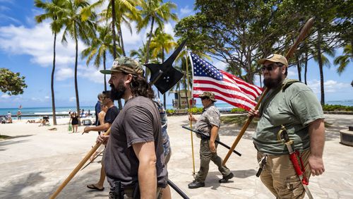 Members of Hawaii Firearms Coalition walk around Waikiki with their non-firearm weapons on Saturday, June 22, 2024, in Honolulu, Hawaii. (AP Photo/Mengshin Lin)