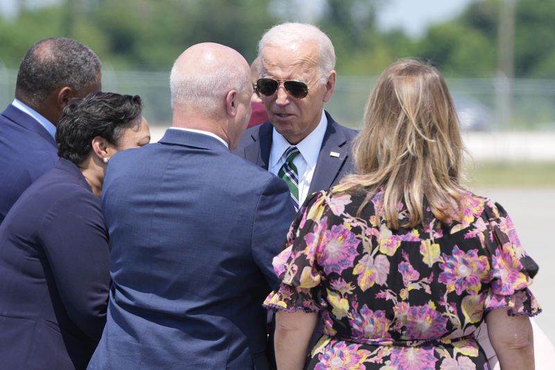 President Joe Biden greets former New Orleans Mayor Mitch Landrieu and his wife Cheryl Tuesday, Aug. 13, 2024, at Louis Armstrong International Airport in New Orleans. (AP Photo/Mark Schiefelbein)